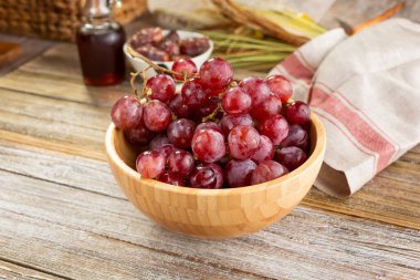 Bir kase kırmızı masa üzümü manzarası, durgun bir hayat ortamında.