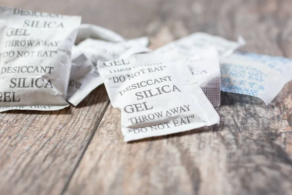 Closeup View Several Packets Desiccant Silica Gel Wooden Surface — Stockfoto