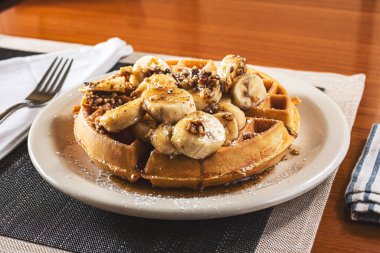 Bir tabak muzlu fındıklı waffle manzarası.