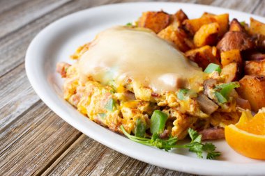 İçinde erimiş peynirli omlet bulunan patates tabağı manzarası..