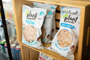 Los Angeles, California, ABD - 10-25-2021: Yerel bir bakkalda sergilenmekte olan birkaç torba Plant Snacks çiftlik aromalı kasava cipsi manzarası.