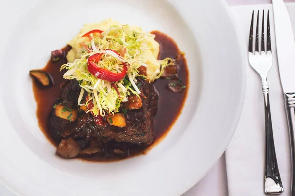 Ağır ateşte pişmiş bir tabak pirzola..