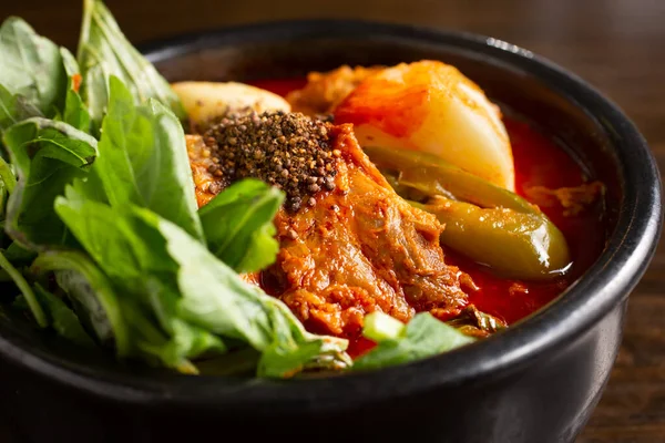 Kore çorba kasesinin yakın plan görüntüsü, domuz boynu kemikleri ve patates var..