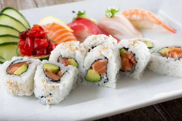 Somonlu avokado dilimli bir tabak ve çeşitli nigiri..