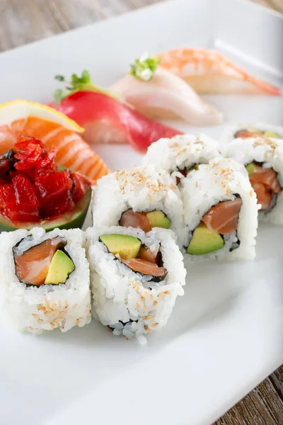 Somonlu avokado dilimli bir tabak ve çeşitli nigiri..