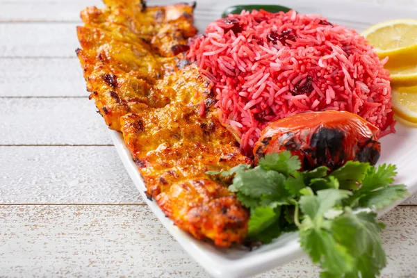 Bir tabak İran tavuğu ve vişneli pilav manzarası.