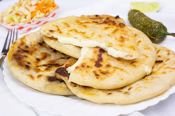 A view of a plate of cheese filled pupusas.