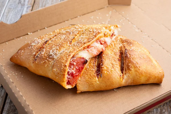 Över Halv Skuren Calzone Inuti Kartong Pizza Box — Stockfoto