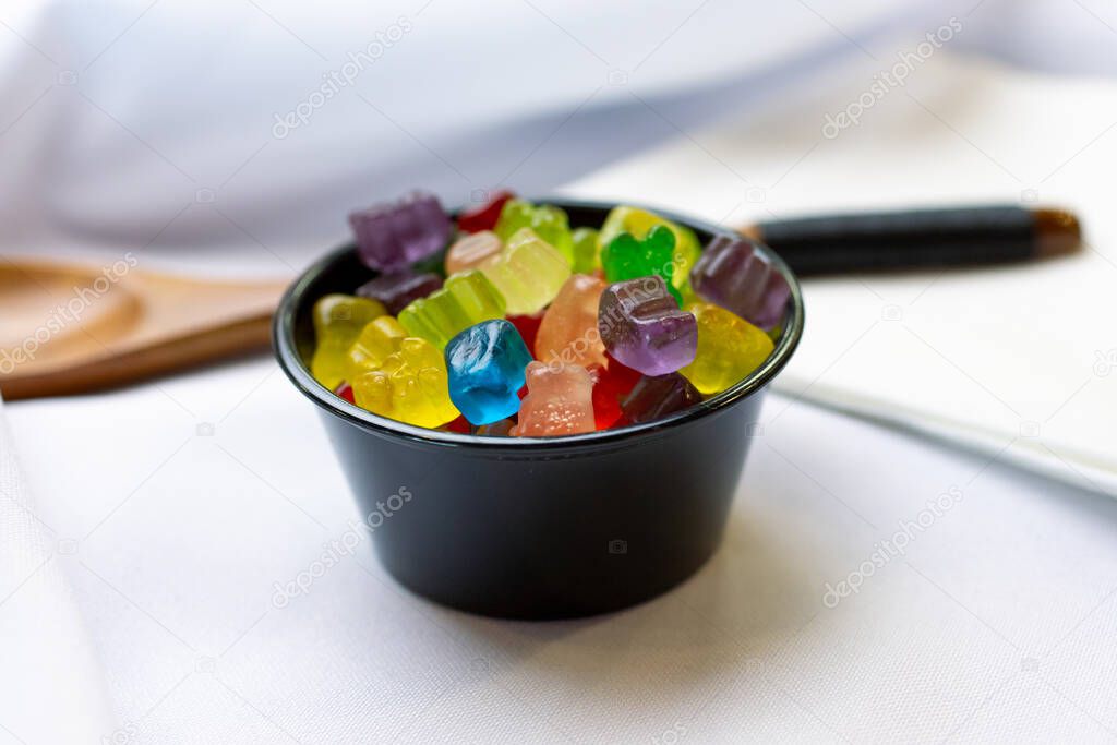 A closeup view of a small cup of tiny gummy bears.