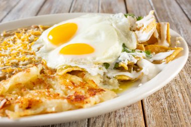 Meksika kahvaltı tabağının yakından görüntüsü, içinde chilaquiles, güneşli yumurtalar var..