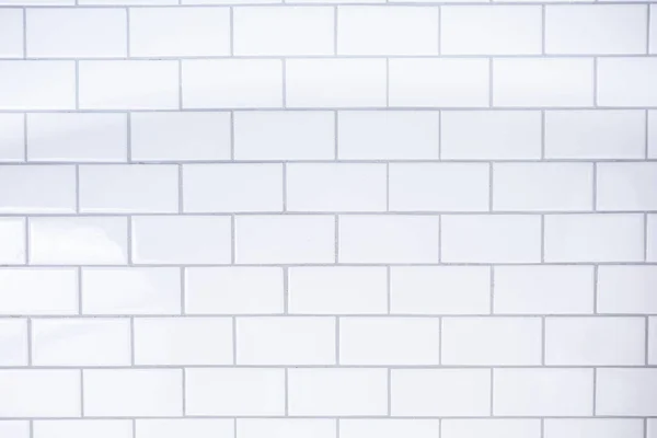 A background of white modern subway tile in natural lighting for restaurant or industrial settings.