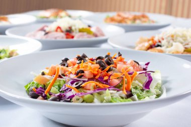 Bahçe salatası içeren birkaç salata tabağı manzarası..