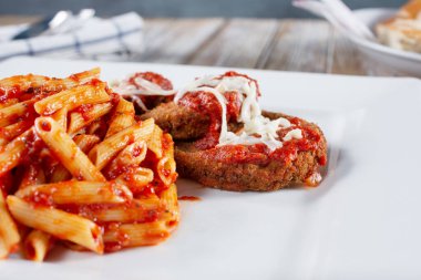 Bir tabak parmesanlı tavuk ve makarna manzarası..