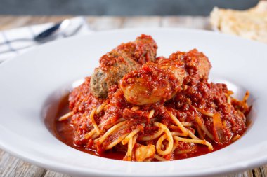 Köfteler ve sosislerin yer aldığı bir tabak spagetti yakın plan görüntüsü..