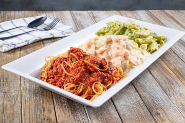 Bir tabak tavuk pesto, fettuccine alfredo ve spagetti marinara..