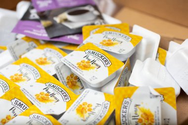 Los Angeles, California, United States - 02-24-2021: A closeup view of several packets of Smucker's Pure Honey.