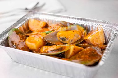 Yeşil midyelerden oluşan teneke bir kabın görüntüsü..