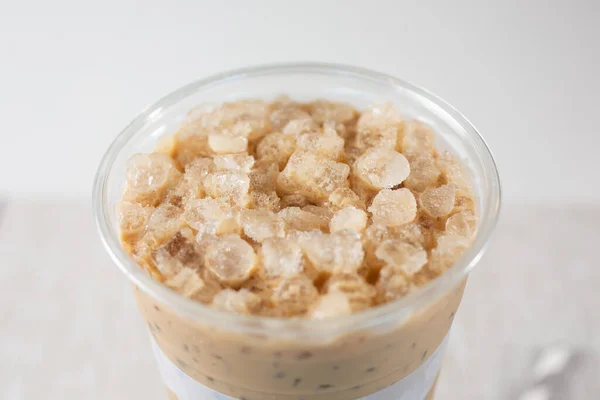 A closeup view of a cup of Vietnamese milk coffee with crushed ice.