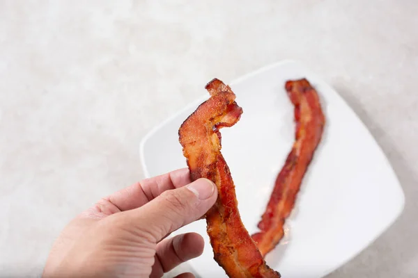 View Hand Holding Strip Cooked Bacon — Stockfoto