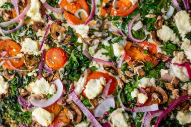 Kırsal bir sebze ve parçalanmış peynirli pizzanın yukarıdan görünüşü..