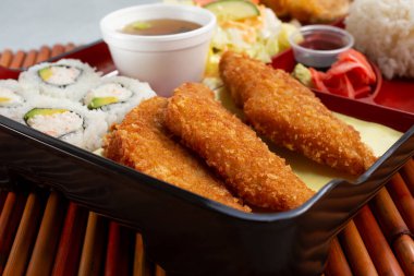 Kaliforniya dürümleri ve tofu keklerinin yer aldığı bento kutusunun yakın plan görüntüsü..