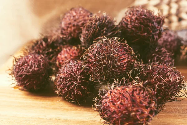 Tahta kesme tahtasındaki birkaç Rambutan meyvesiyle yakın çekim görüntüsü..