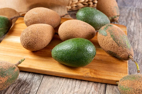 Tahta kesme tahtasındaki olgunlaşmamış avokadoların görüntüsü..