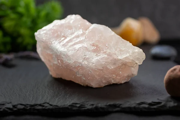 A closeup view of a chunk of rose quartz rock crystal, in a still life setting.