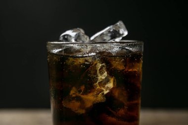 Solt içecek bulanık gölgeli arka planda buzlu bir bardağa doluyor.