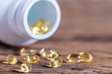 Arka plandaki bulanık haplar sarımsak içeren kapsüller, tıbbi bir bitki COVID-19 için bağışıklık ve tedavi özellikleri, şişeden dökülen vitamin, Macro...