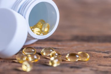 Arka plandaki bulanık haplar sarımsak içeren kapsüller, tıbbi bir bitki COVID-19 için bağışıklık ve tedavi özellikleri, şişeden dökülen vitamin, Macro...