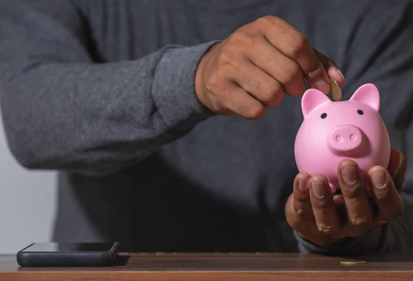 Save money and account banking for finance concept, Man with piggy bank and coin on blurred background, Save Monney for Investors Using Internet to Trade Stocks or Trade Fund