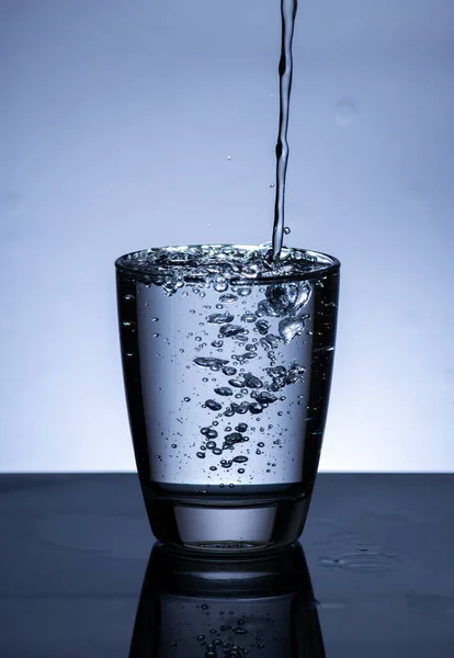 The image of pouring drinking water, into a glass, that makes one feel refreshed on blurred white background, Splashing water, Sparkling water