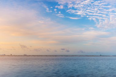 Beach günbatımı veya gündoğumu ile renkli bulut gökyüzü ve güneş ışığında akşam ışığı