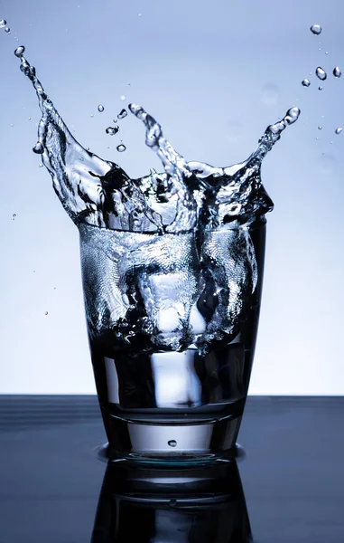 The image of pouring drinking water, into a glass, that makes one feel refreshed on blurred white background, Splashing water, Sparkling water