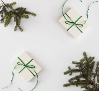 Beyaz arka planlı ev yapımı bir hediye ve köşelerde kozalaklı brunchlar.