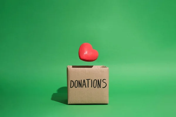 Levitating Heart Falling Charity Donations Box Green Background — Stock Photo, Image