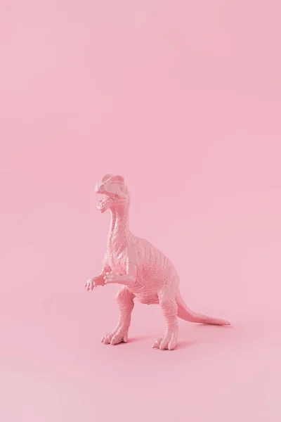 粉红漆成的恐龙被隔离在粉红的粉刷背景上 具有复制空间的极小单色创作概念 — 图库照片