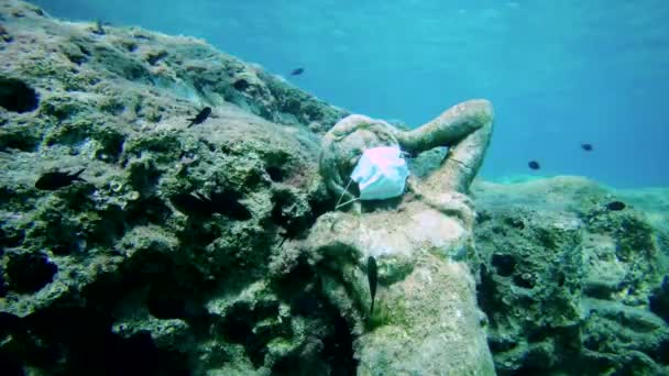 Statua in maschera medicina sul fondo del mare e diversi pesci accanto ad essa. — Video Stock