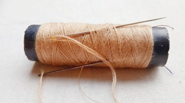 Bu fotoğraf iplik ve iğne hakkında. Genellikle elle dikmek için kullanılır.