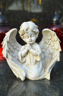 Melek heykeli mezarda diz çöküyor.