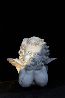 Melek heykelciğine başsağlığı kartı, kopyalama alanı olan koyu bir arkaplan.