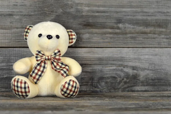 Teddy bear soft toy on wooden background with copy space