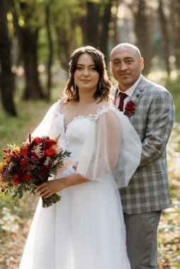 Gelin ve damadın yürüyüşü Ekimde sonbahar ormanında