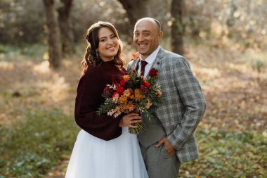 Gelin ve damadın yürüyüşü Ekimde sonbahar ormanında