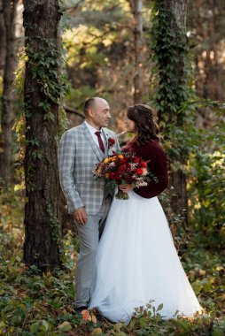 Gelin ve damadın yürüyüşü Ekimde sonbahar ormanında