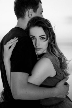 Gün batımında pembe tuz gölünün kıyısında bir adam ve bir kız.