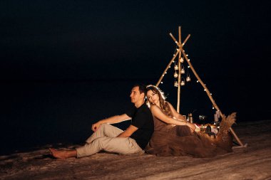 Genç çift pembe gölün sahilinde piknik yapıyor.