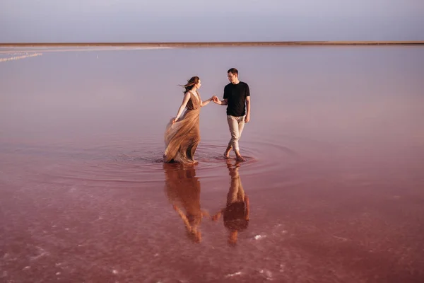 Mädchen Und Ein Mann Ufer Eines Rosa Salzsees Bei Sonnenuntergang — Stockfoto