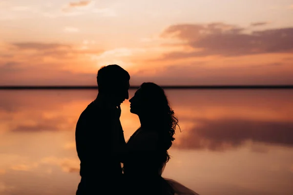 Gün Batımında Pembe Tuz Gölünün Kıyısında Bir Adam Bir Kız — Stok fotoğraf